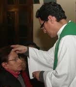 Priest in Green Anointing Woman